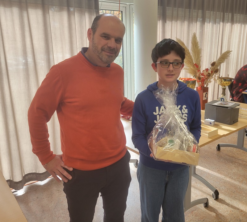 M. Desouches, directeur de Super U Liffré, remet le panier au jeune David Lacanrus, Champion du monde U10 en 2022